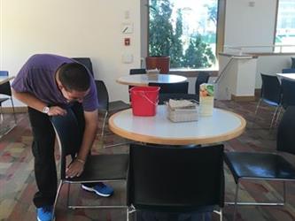 A student cleaning a chair