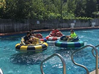 Students in large inner tubes floating in a pool 