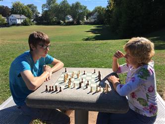 2 students playing chest in a park